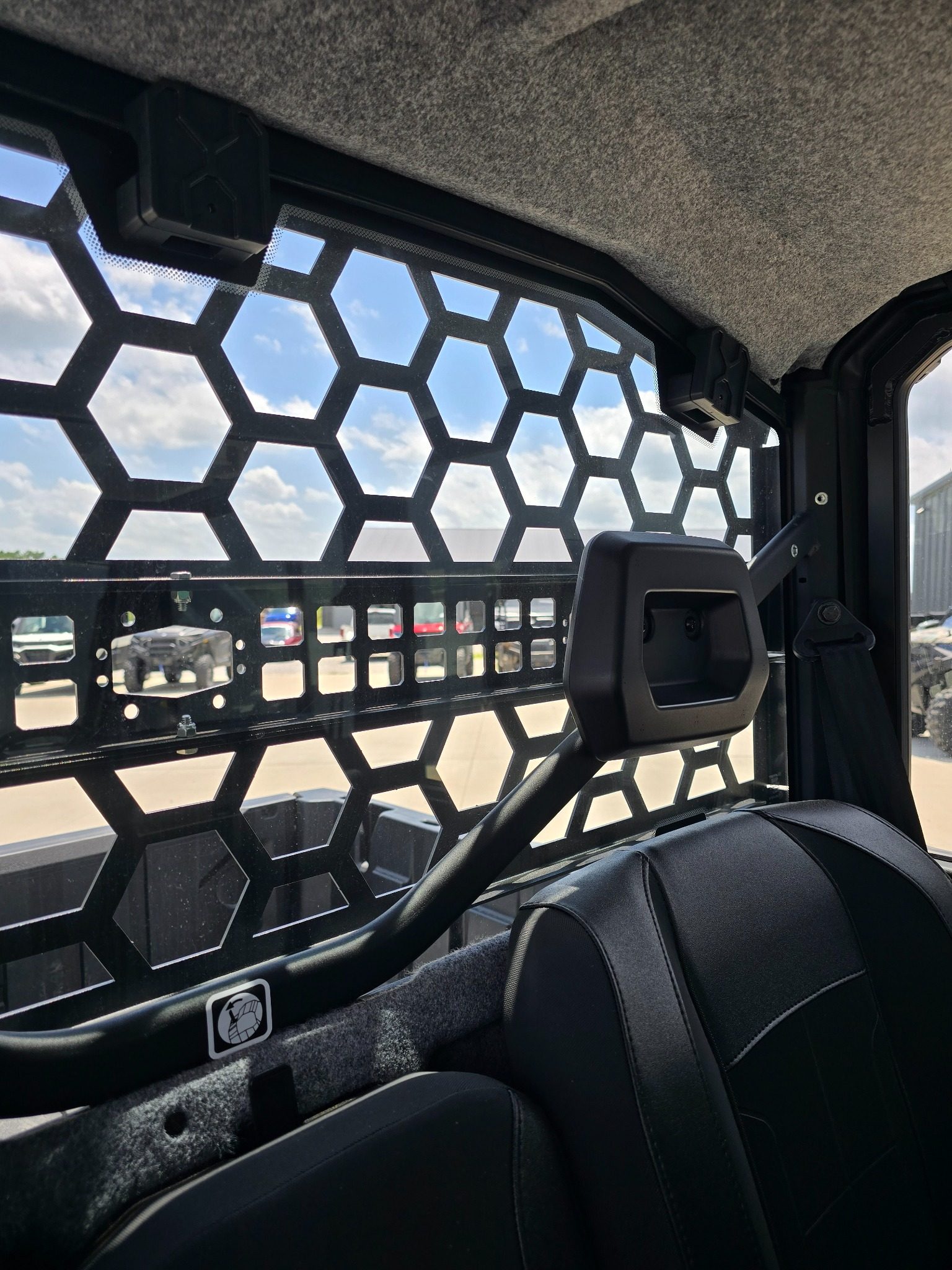 Interior view through Can-Am Defender HD11 Headache Rack showing rear visibility from inside the cab